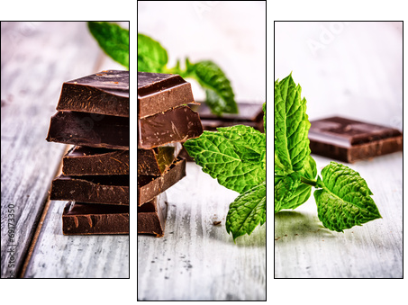 A few cubes of black chocolate with mint leaves on wooden table - Three-piece canvas print, Triptych