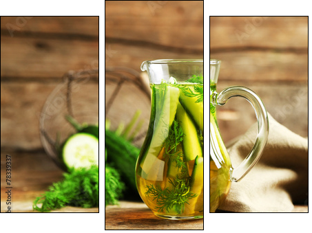 Glass ewer with fresh organic cucumber water on wooden table - Three-piece canvas print, Triptych